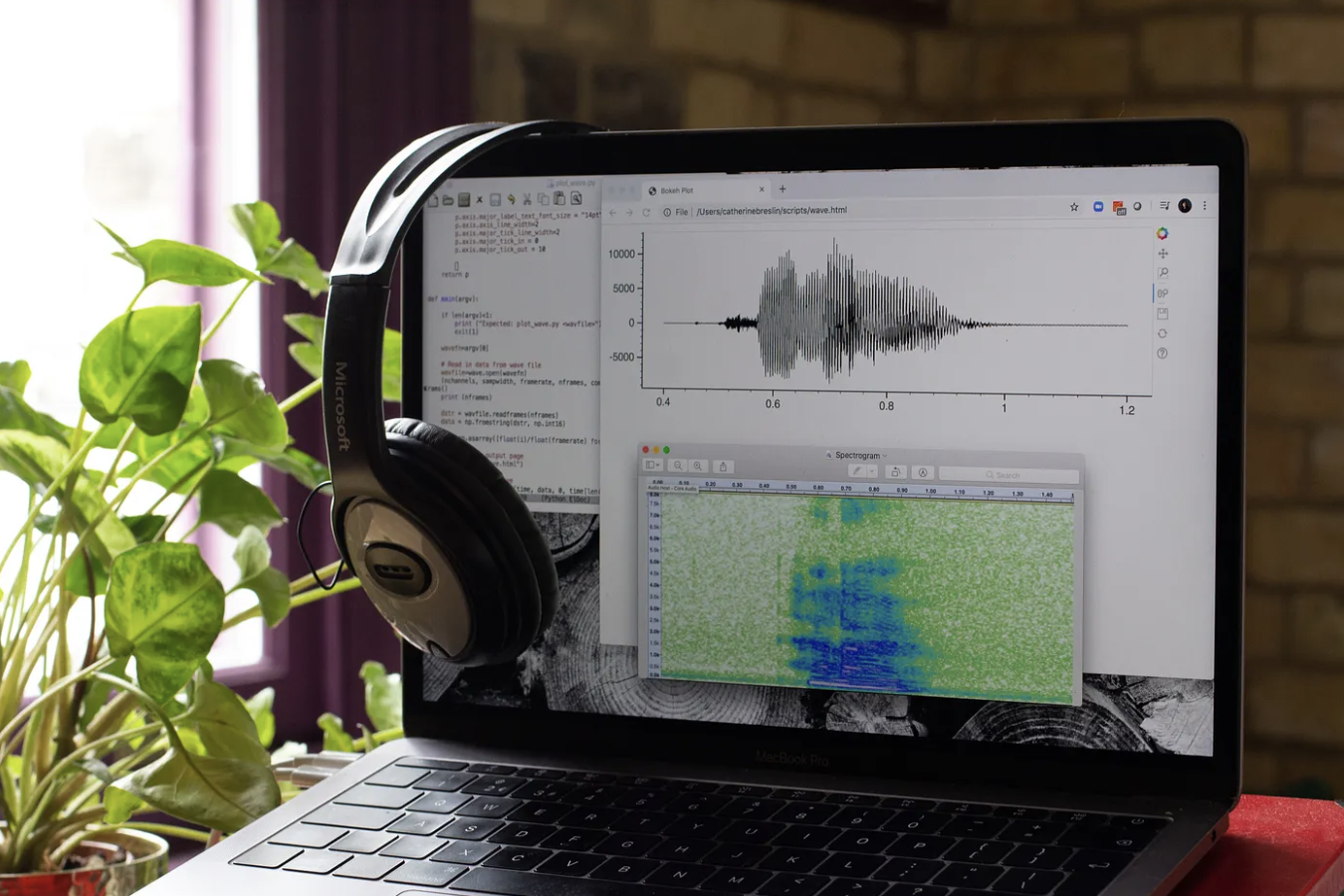 Laptop with headphones running audio software showing a waveform and its spectrogram — cover photo by Catherine Breslin on Unsplash